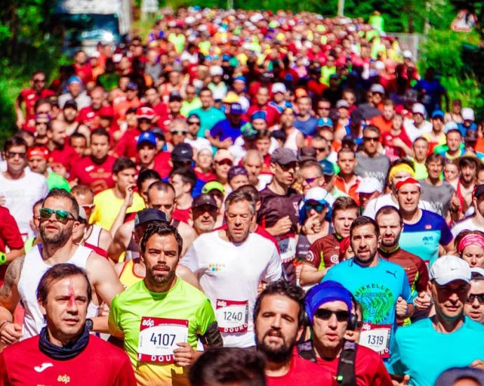 A large group of diverse marathon runners competing in a vibrant outdoor race.