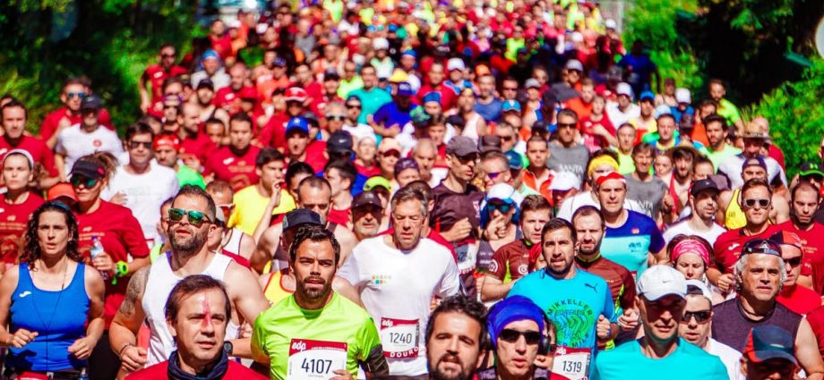 A large group of diverse marathon runners competing in a vibrant outdoor race.
